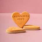 Heart-shaped cookies with 'CHARMAINE'S HEN'S' text on a pink background