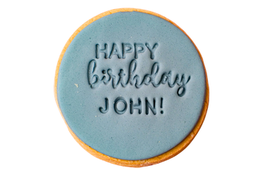 Round blue cookie with 'Happy birthday John!' text on a white background