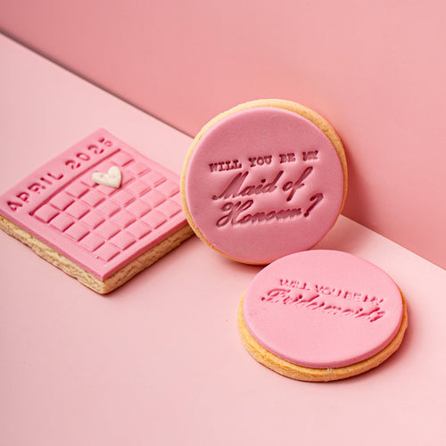 Three pink cookies with text on a pink background