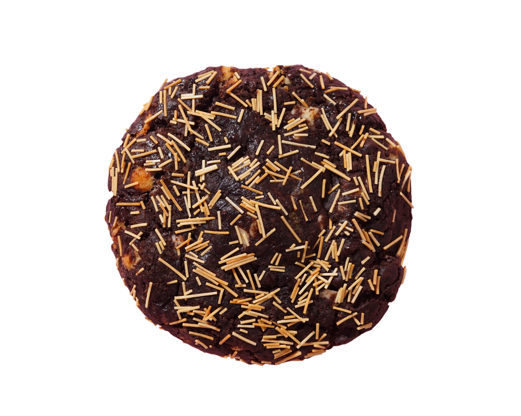 Chocolate cookie with gold sprinkles on a white background